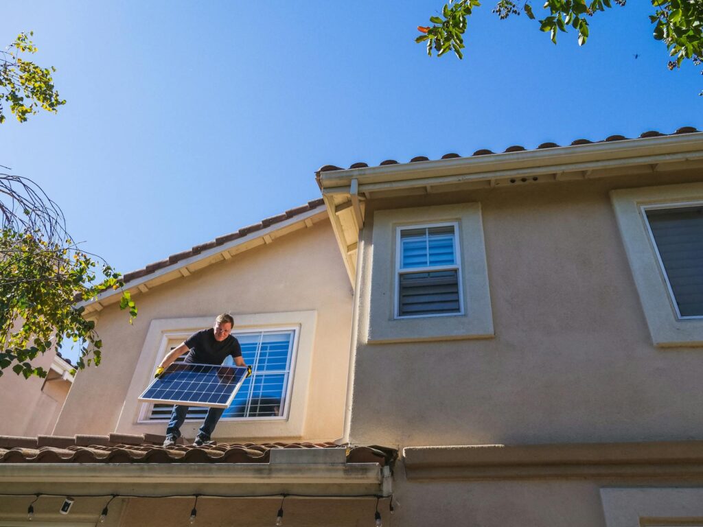 A smiling family standing in front of their solar-powered home. — Nevada energy incentives for homeowners