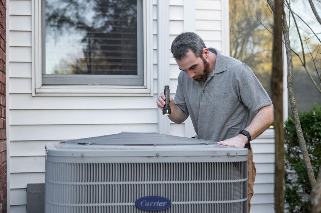 A technician performing maintenance on an HVAC unit. — seasonal energy saving tips Nevada