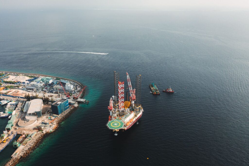 An image depicting renewable energy sources alongside oil rigs — oil and gas investment