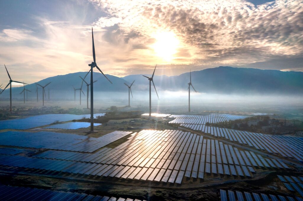 A vibrant landscape of Nevada showcasing solar panels and wind turbines, representing renewable energy sources in the stat…